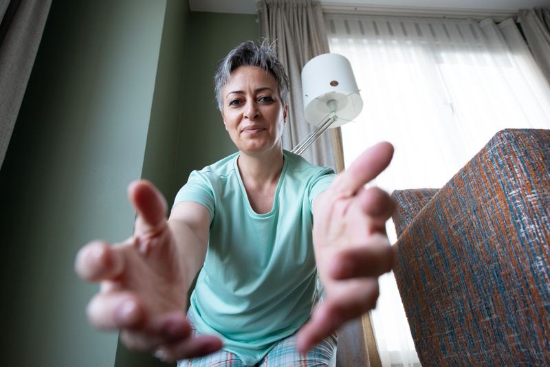 A woman adjusts her home security camera