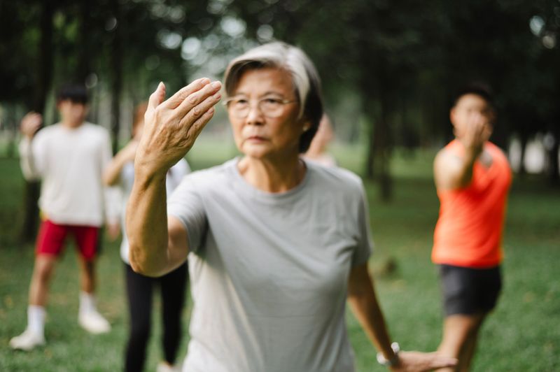 Close up of group of people practicing Tai Chi.