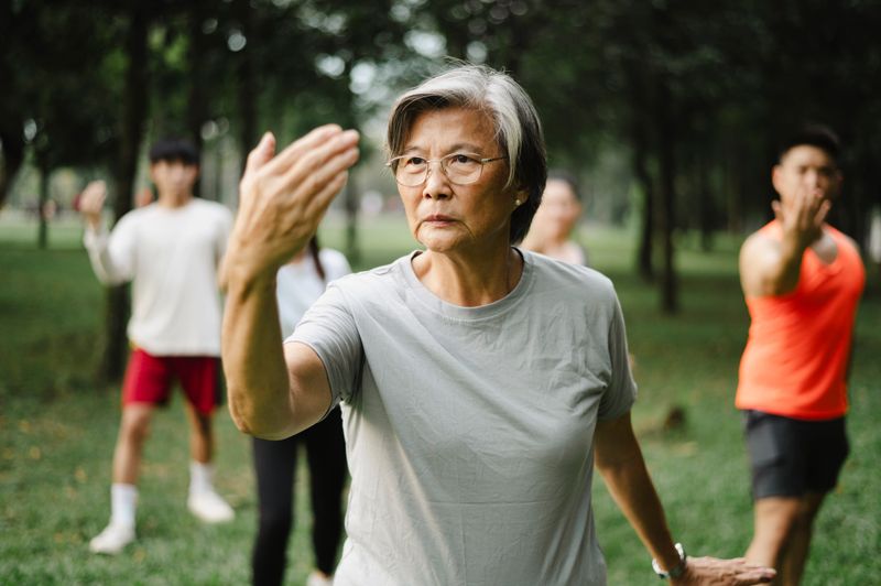 Active senior mother teaching her family Tai Chi.