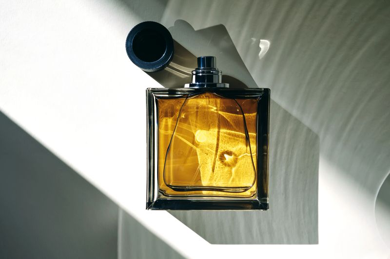 Perfume bottle in the rays of bright sun with beautiful highlights. High quality photo.
