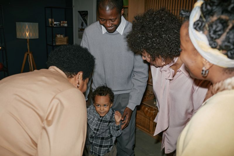 Family bonding moment with African American members smiling and interacting, creating a warm and joyful atmosphere in a cozy indoor setting