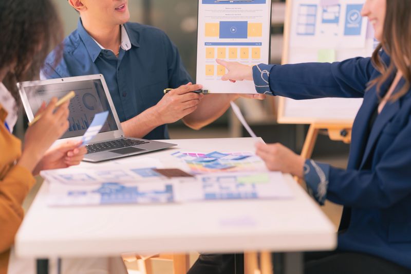 A design team focused on analyzing interface layouts and brainstorming to improve the user experience in a mobile responsive workshop with UI/UX Front End Designer Previewing.