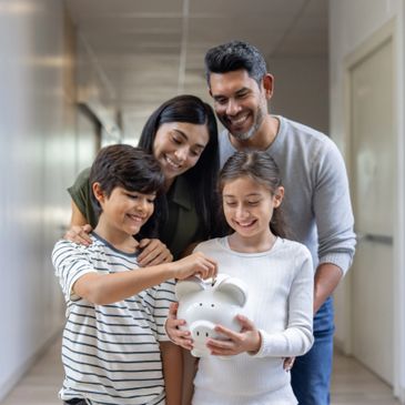 Family happily saving money together with a piggy bank.