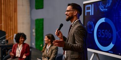 A man in a suit gives a presentation on AI to an engaged audience.
