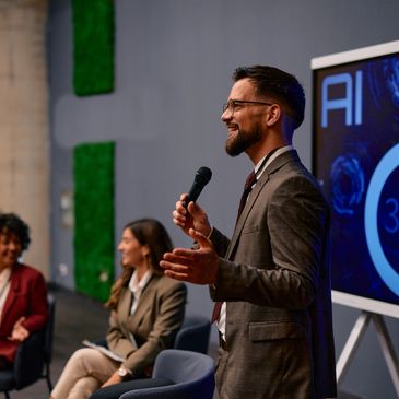 Two people working at a wooden table with notebooks, tablet, and coffee.