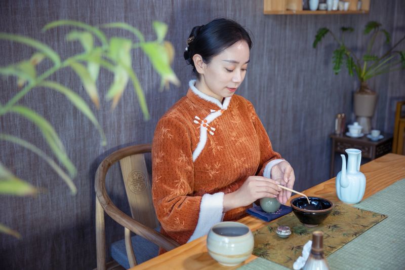 The tea master pours tea powder into the tea bowl