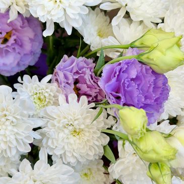 A bouquet of white chrysanthemums and purple lisianthus flowers.