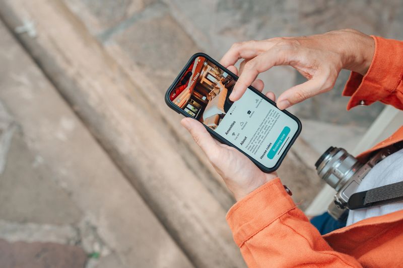 Group of mature adult friends quickly booking a hotel on smartphone while exploring the temple, making use of technology to simplify their travels and ensure a smooth, enjoyable experience