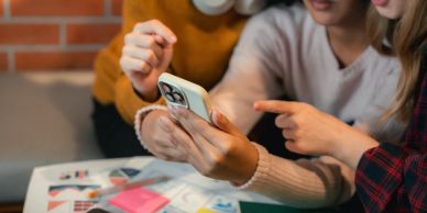 Three people looking at a smartphone together.