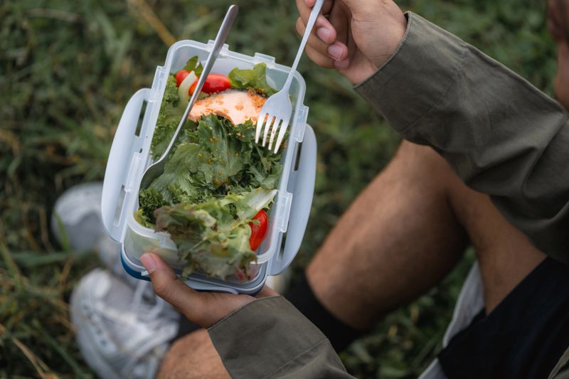 Young man enjoying a peaceful picnic alone, eating healthy food, relaxing in the serene surroundings