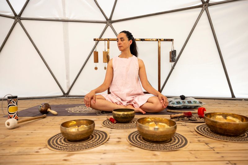 Woman using a singing bowl during a sound therapy session