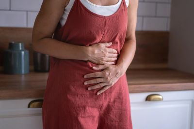 Person holding stomach in discomfort.