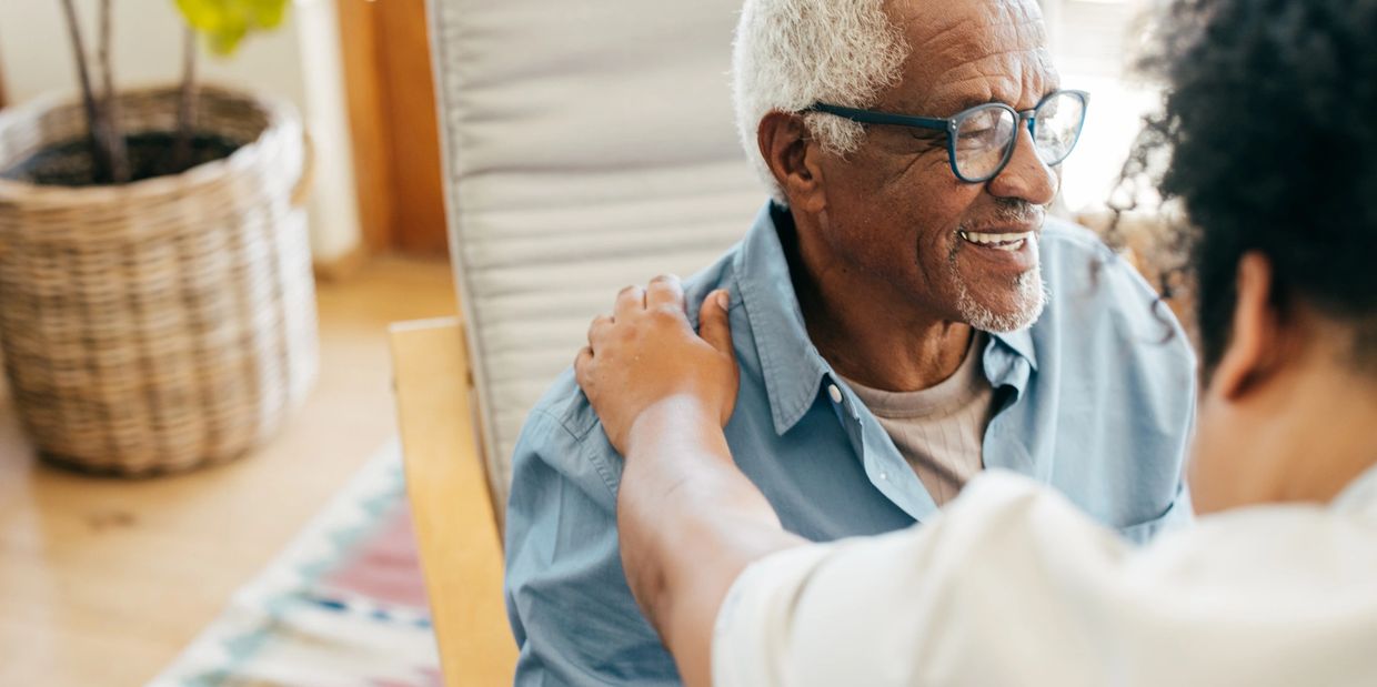 Smiling caregiver spending quality time with an elderly client at home