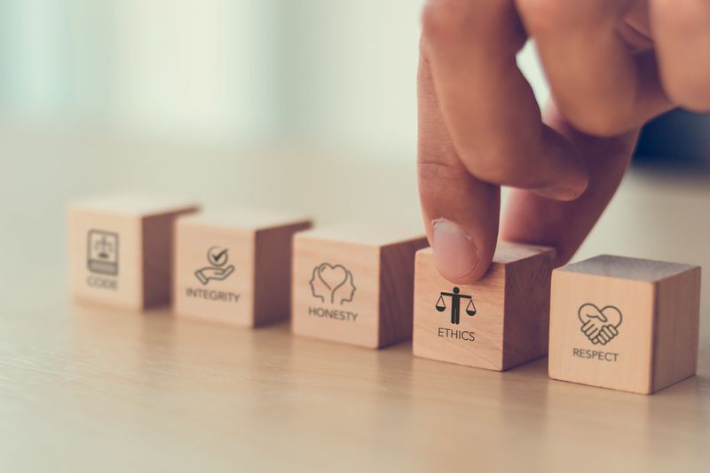 Code of conduct in business concept. Wooden blocks with code of conduct icons; code, integrity, honesty, respect, and ethics,  the foundation of a strong corporate code of conduct. Corporate ethics.