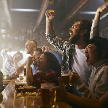 Group of friends cheering and celebrating at a bar.