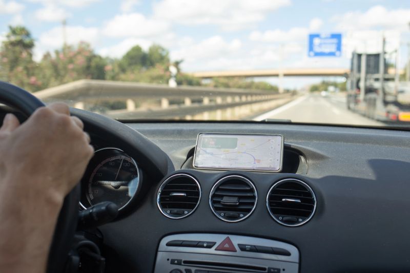 A traveler navigates through Spain's picturesque landscapes, enjoying the open road with a GPS device guiding the way. The journey captures the spirit of adventure and exploration.