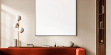 Modern living room with red sofa and blank wall art.