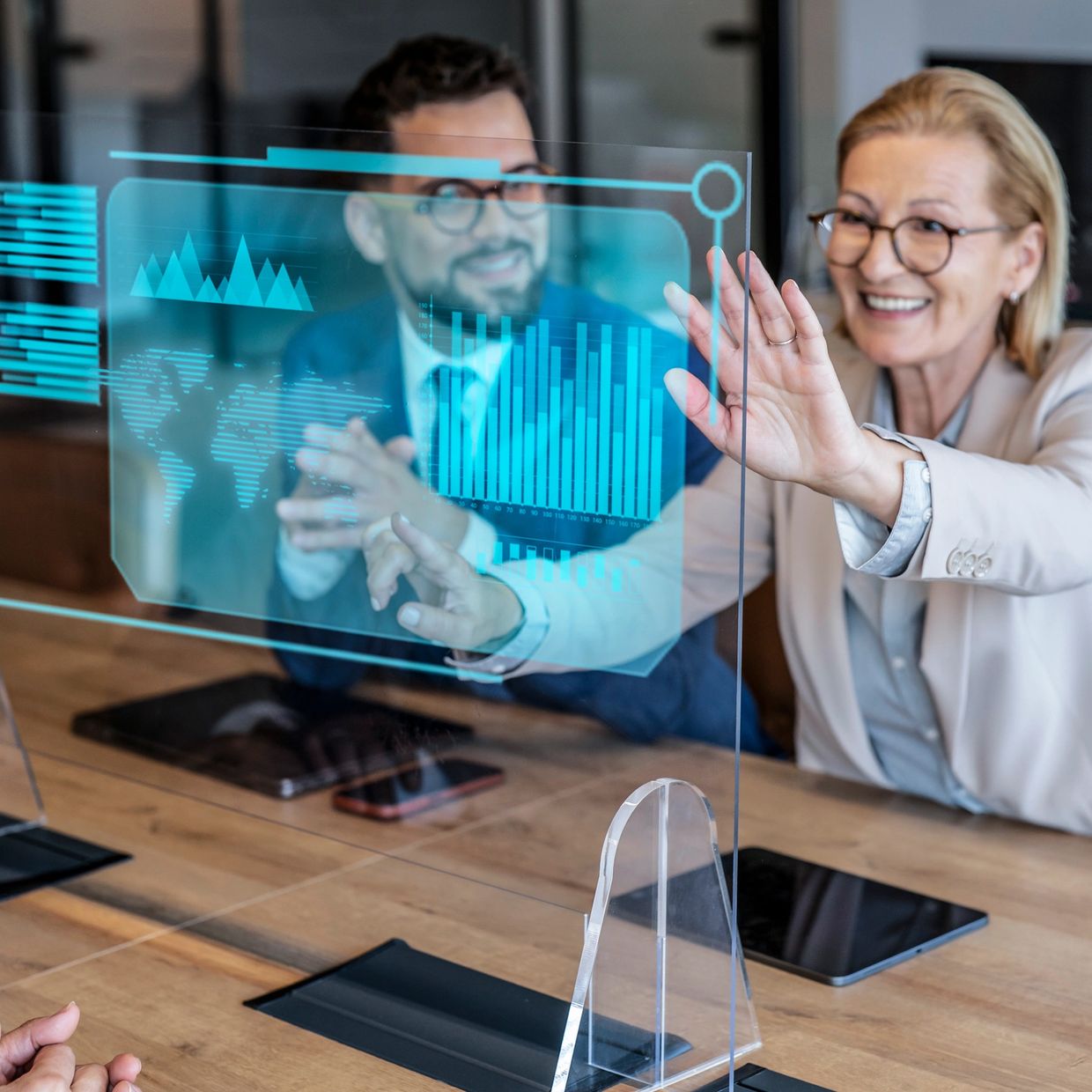 Business professionals interacting with a futuristic transparent digital display in a meeting.