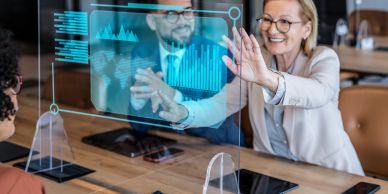 Business professionals interacting with a transparent digital screen.