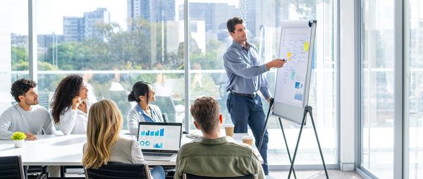Business team reviewing data charts during a presentation in a modern office.