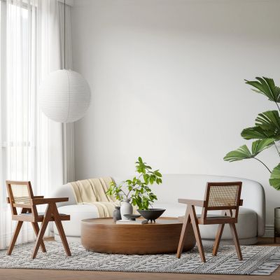 Modern living room with white sofa, wooden chairs, round coffee table, and green plants.