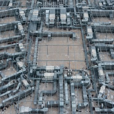 Complex network of industrial ventilation ducts inside a large building.