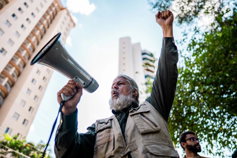 Senior man talking in a megaphone during a environmentalists protesting at city street