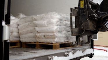 Pallets of white sacks loaded on a truck.