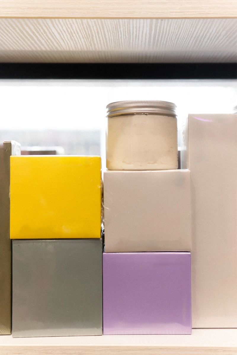 A vibrant collection of boxes and jars are neatly stacked on a shelf, showcasing a range of colors and textures.