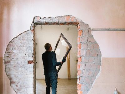 Worker removing a door frame from a rough wall opening.