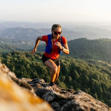 Woman hiking up a rocky mountain.