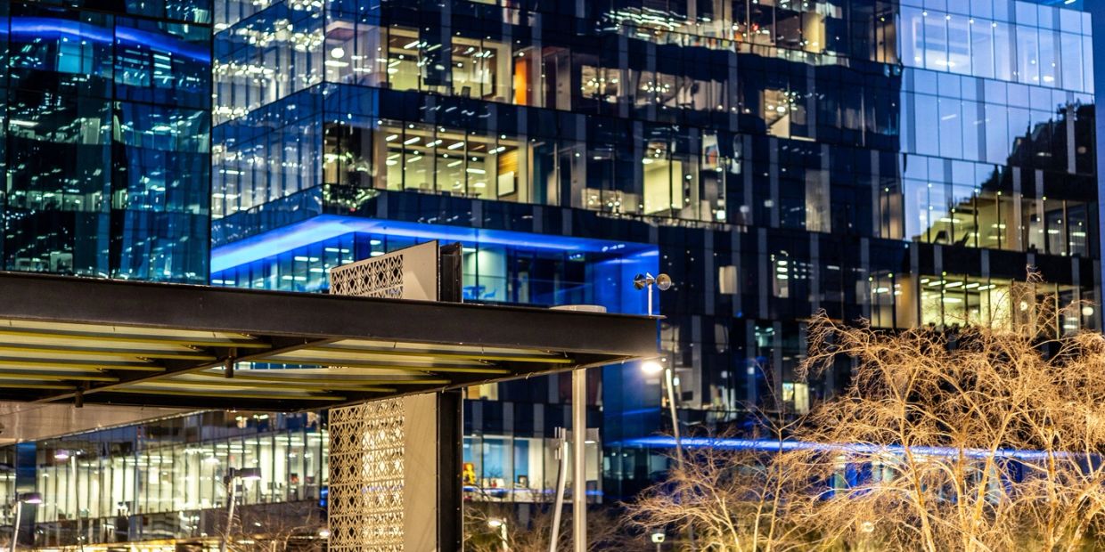 Modern glass office building illuminated at night.