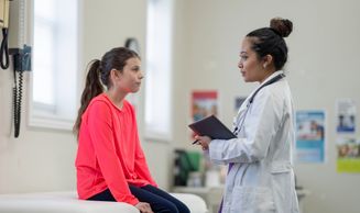 Doctor consulting a young girl in a medical office.