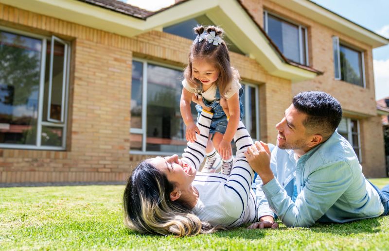 Happy Latin American family playing outdoors in the back yard of their house - lifestyle concepts