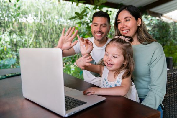 Family video calling on laptop.