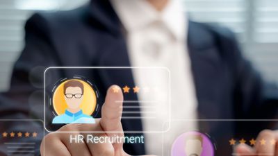 Person selecting HR recruitment profile on a digital screen.