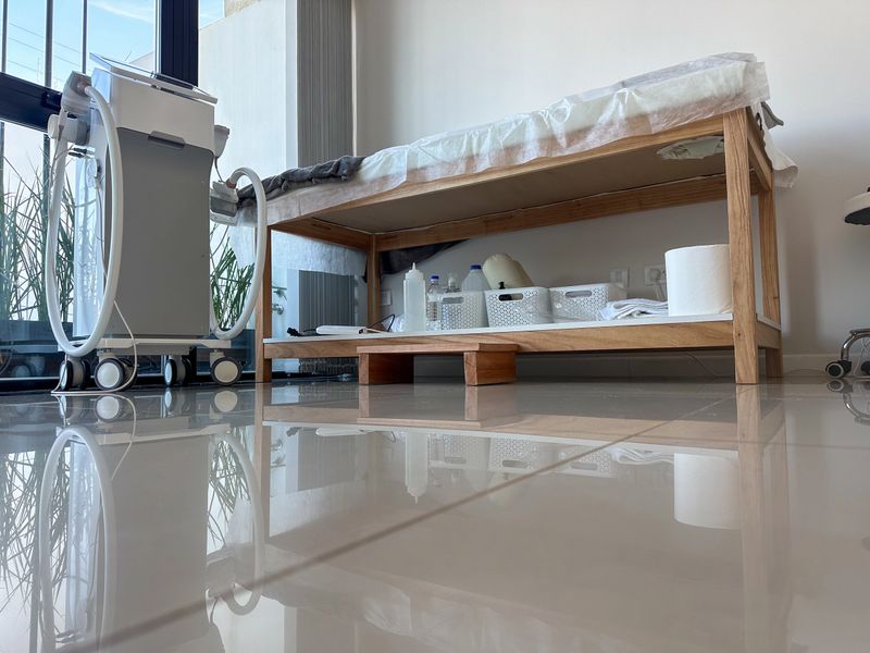 treatment  room in spa clinic with table, towels, equipment, with  sunlight through large window.
