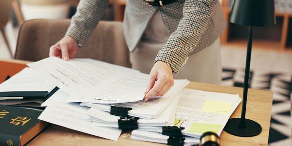 Person organizing legal documents on desk.