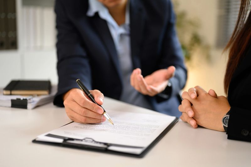 Professional agreement signing between client and business agent in modern office.