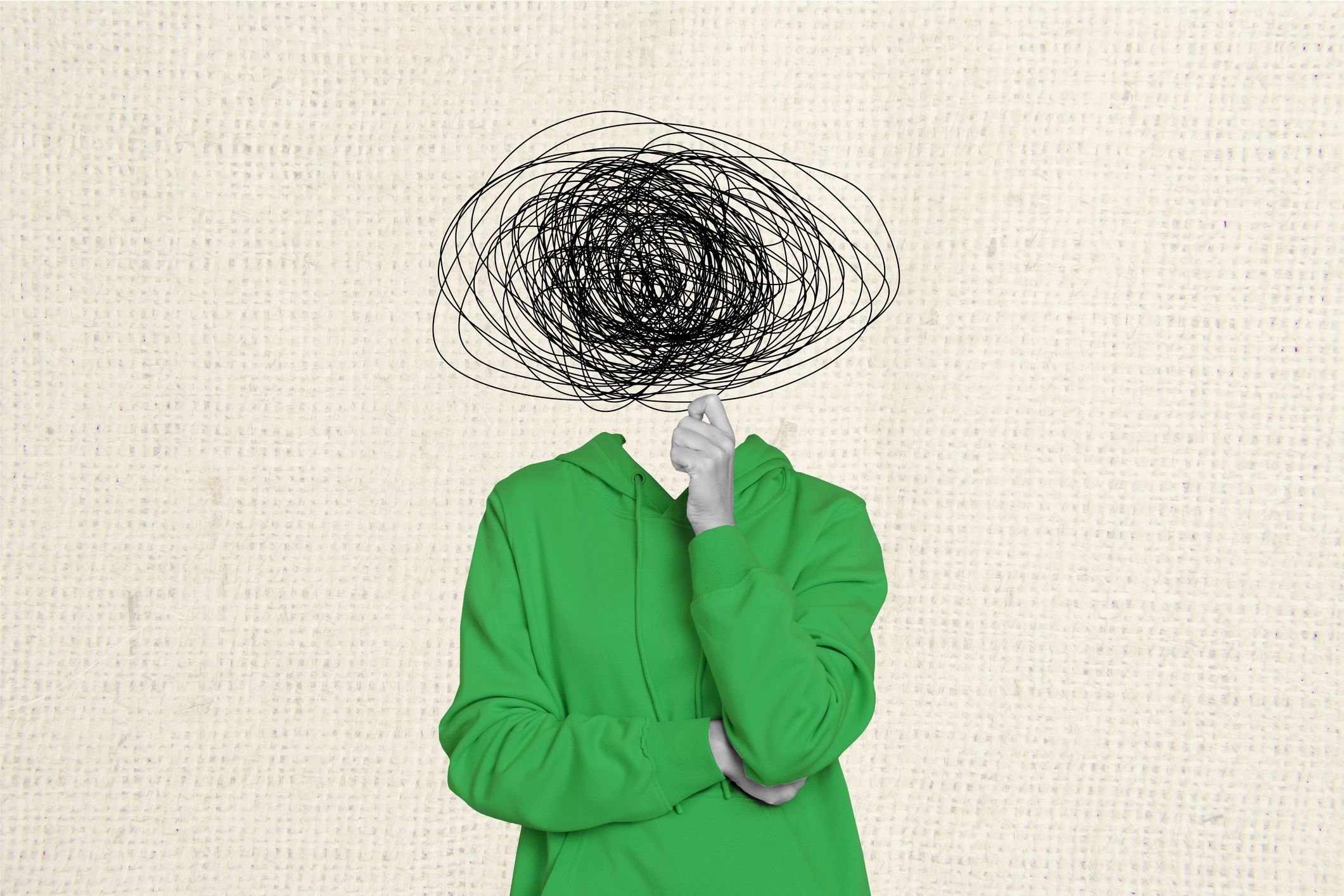 Person in green hoodie with a scribbled head, symbolizing confusion or mental clutter.