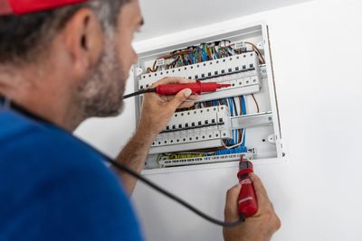Electrician working on a circuit breaker panel.