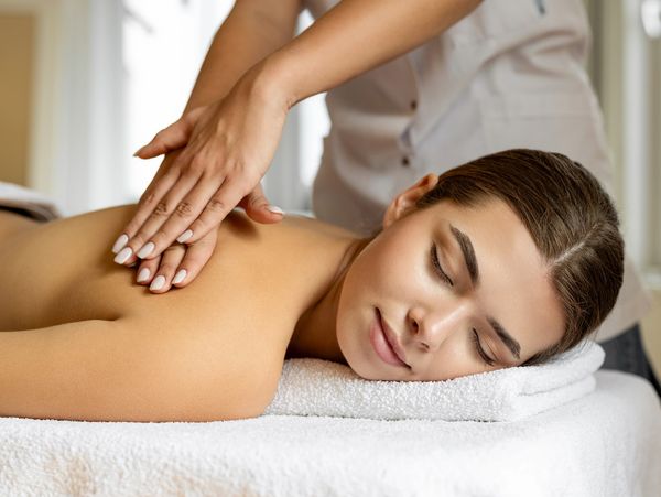 A woman enjoying a relaxing back massage in a spa.