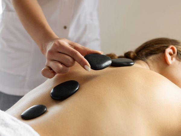 Therapist applying hot stones to back