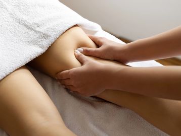 Therapist massaging a person's leg.