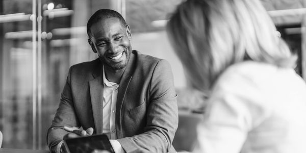 A man in a suit smiling at a woman in front of him