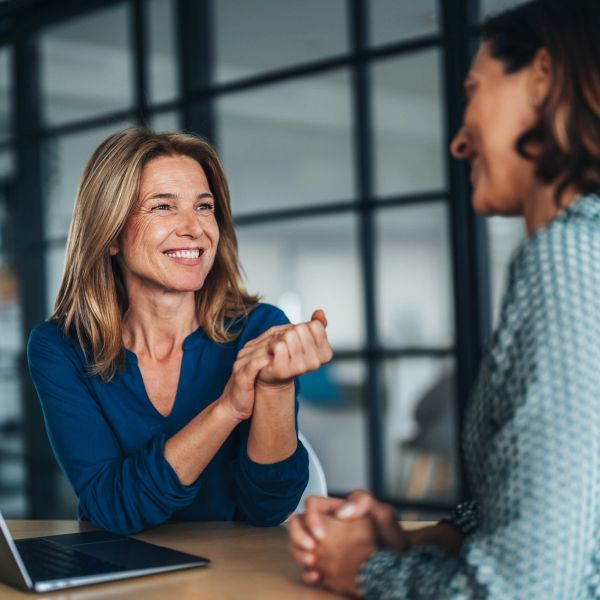 Two women having a friendly conversation at a table.