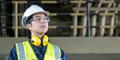 Engineer in safety gear inspecting an industrial site.