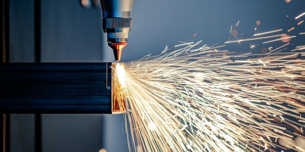 Laser cutting metal with bright sparks flying.