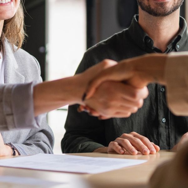 Close-up of a handshake over paperwork in a business meeting.