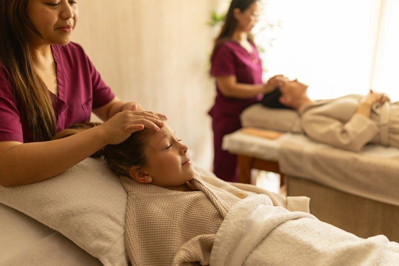 Mother and little daughter enjoying head massage in  Thai massage center